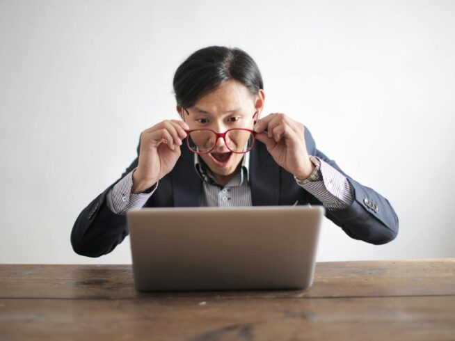 amazed formal male looking at laptop screen